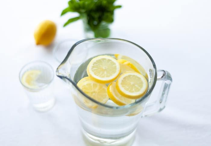 A jug of water with lemons in it
