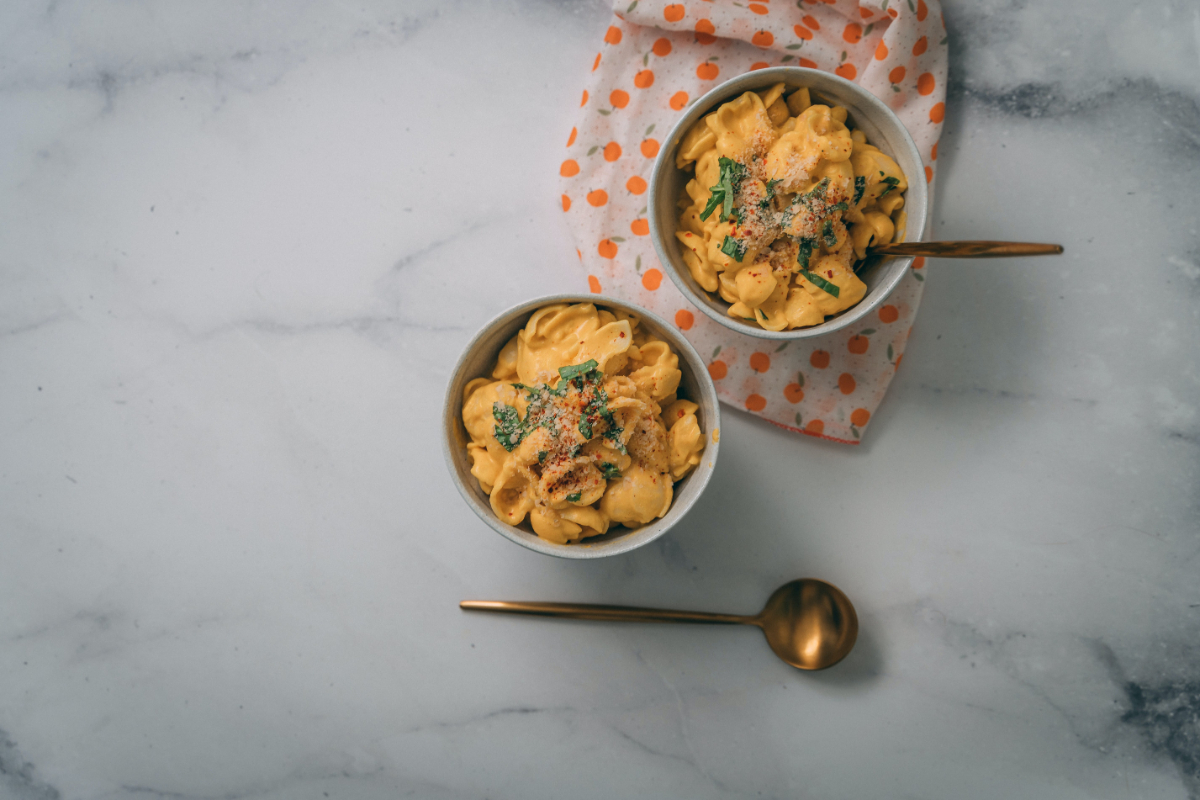 Two Bowls Of Mac And Cheese On A Marble Countertop