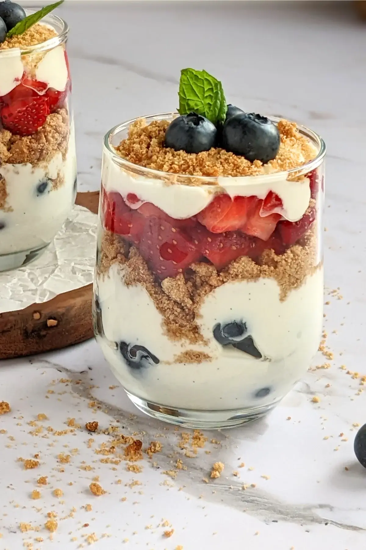 Healthy strawberry and blueberry parfait cups layered with Greek yogurt and fresh berries in clear glasses.