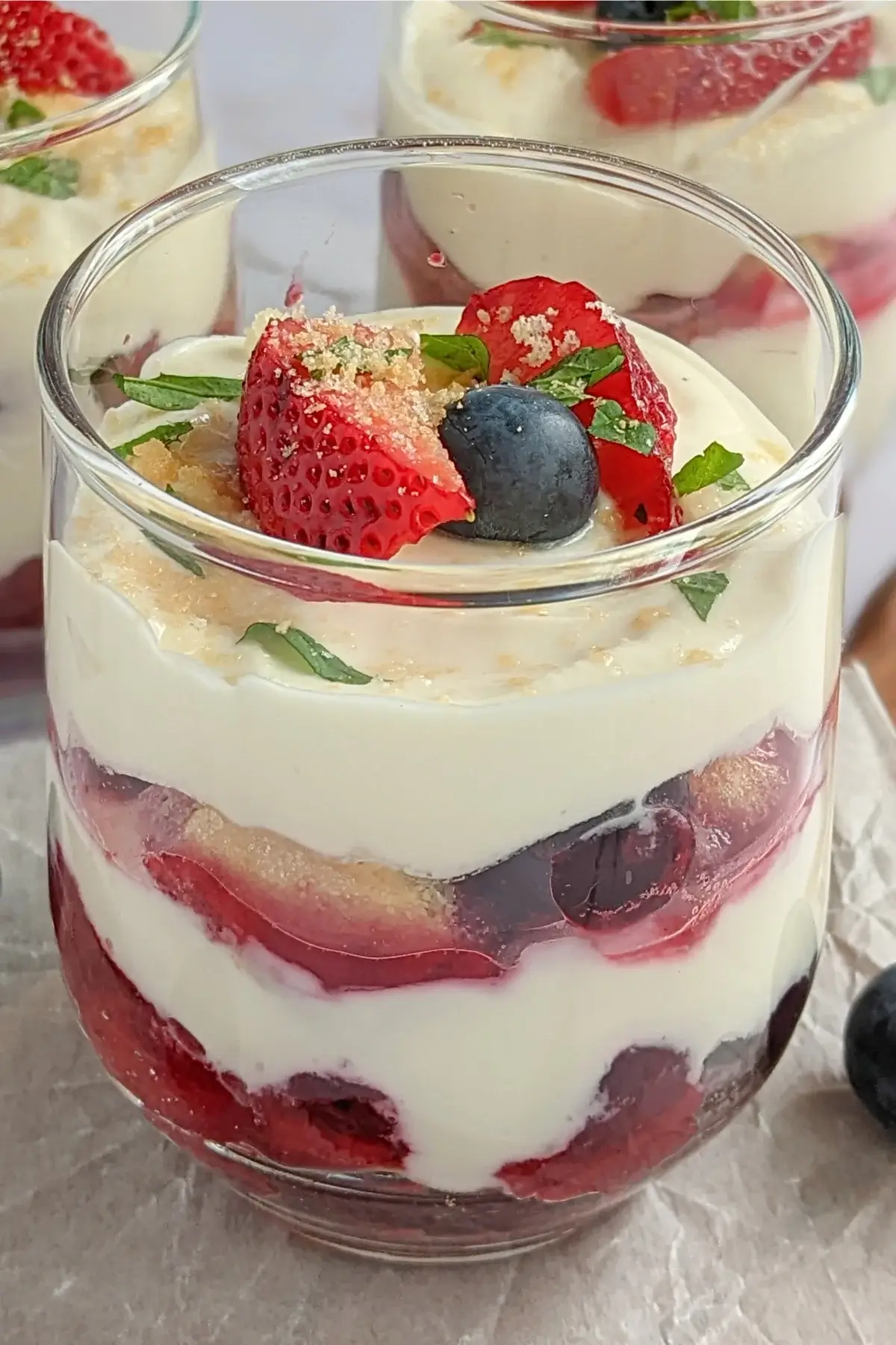 Mixed berry tiramisu in a glass dish with layers of mascarpone, Greek yogurt, and cooked berries.