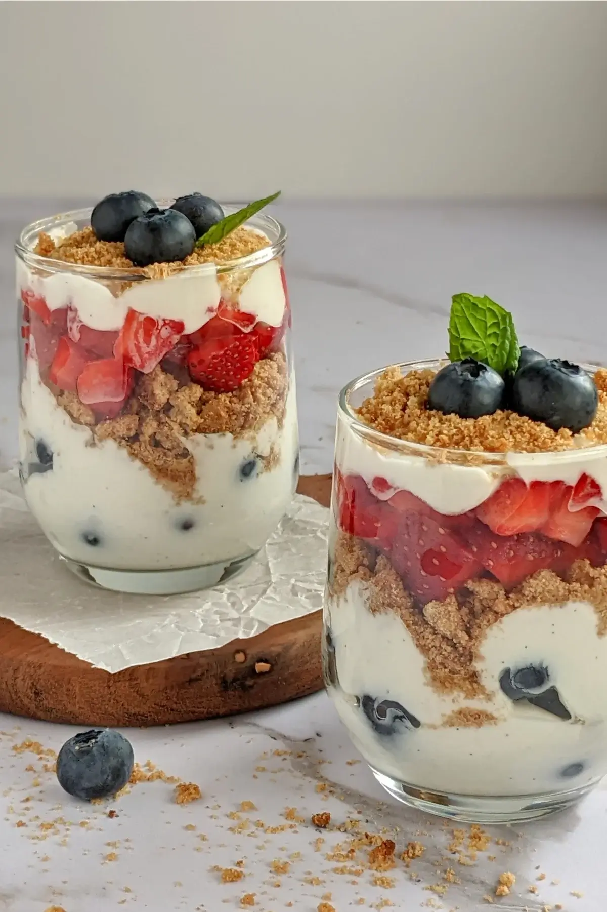 Healthy strawberry and blueberry parfait cups layered with Greek yogurt, fresh berries, and granola.