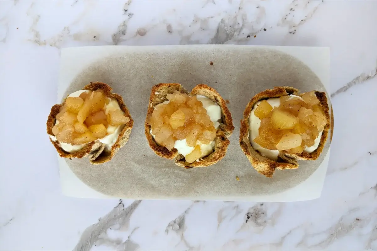 Toasted bread cups filled with whipped ricotta and topped with a spoonful of homemade applesauce.