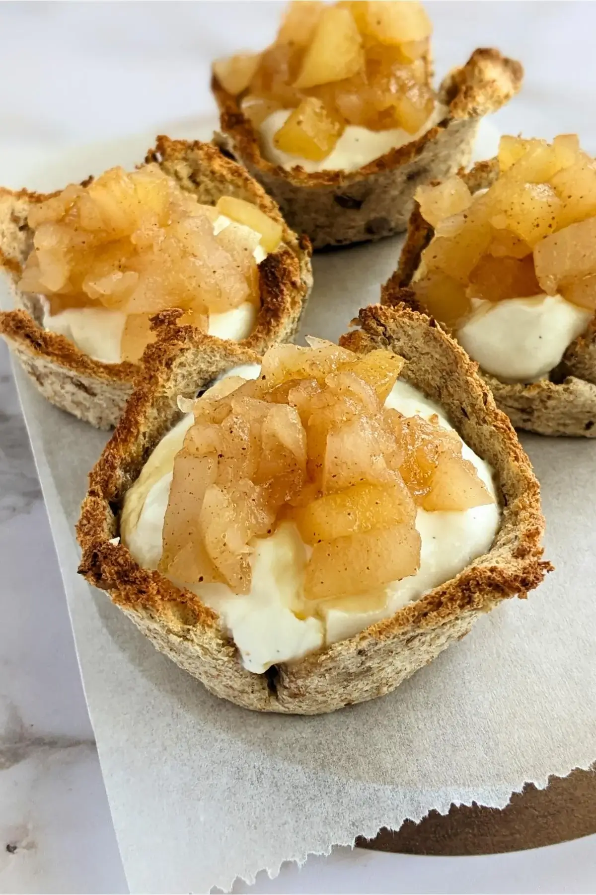 Toasted bread cups filled with whipped ricotta and topped with a spoonful of homemade applesauce.