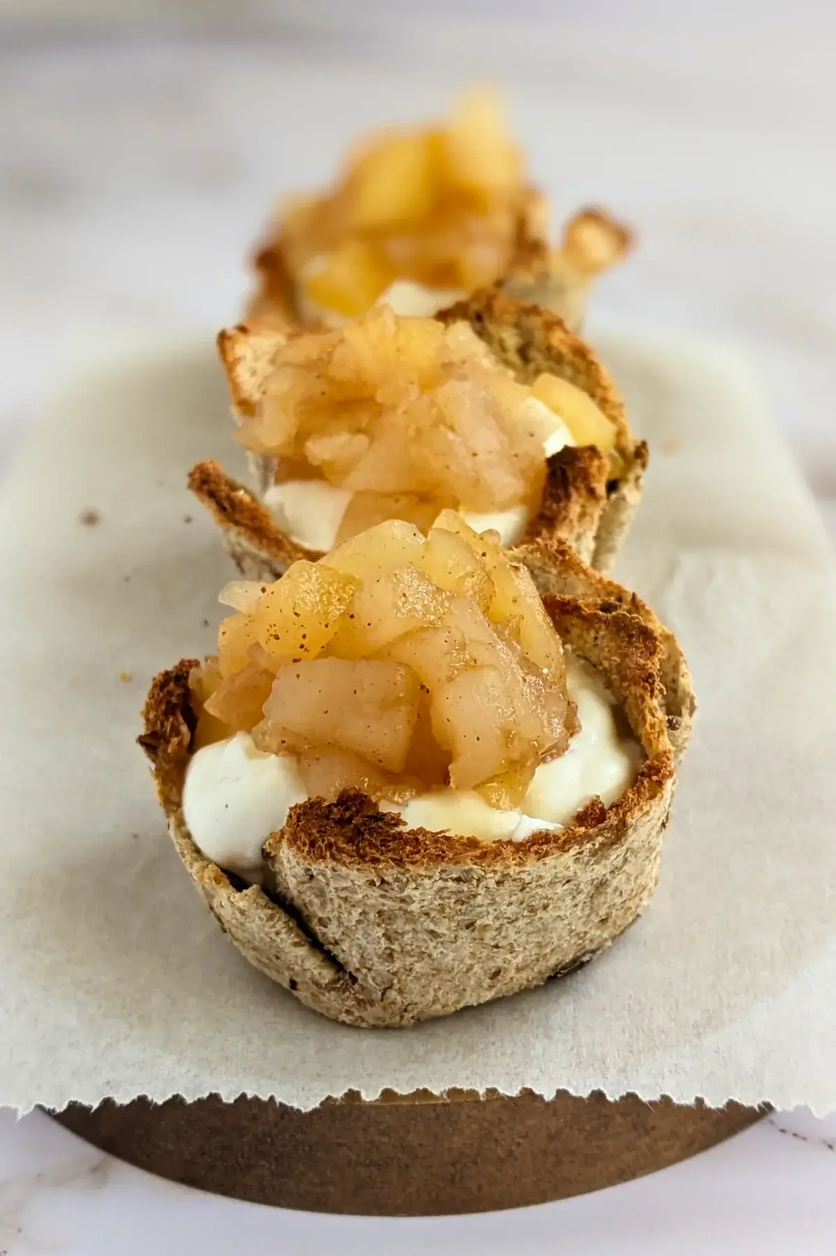 Wholemeal bread cups filled with whipped ricotta and topped with homemade applesauce.