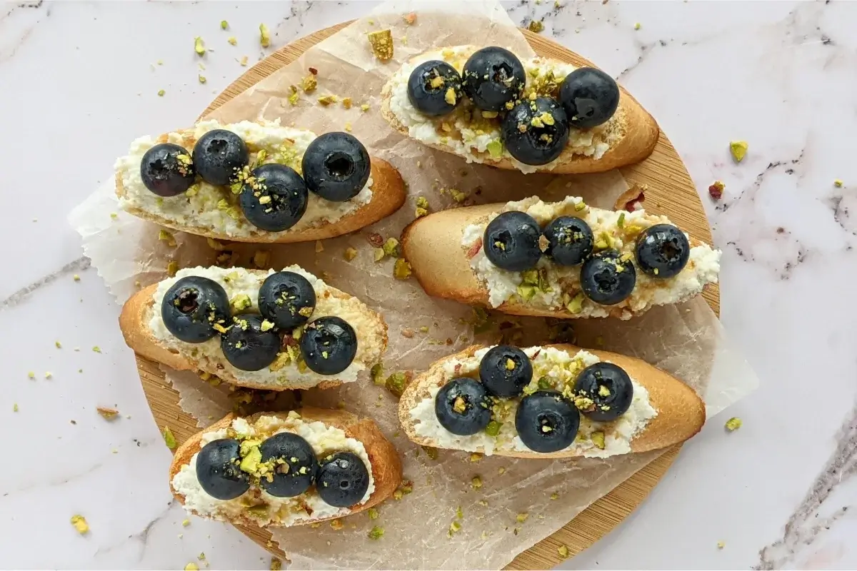 Toasted crostini topped with sweet ricotta and fresh blueberries for a simple yet elegant appetizer or dessert.