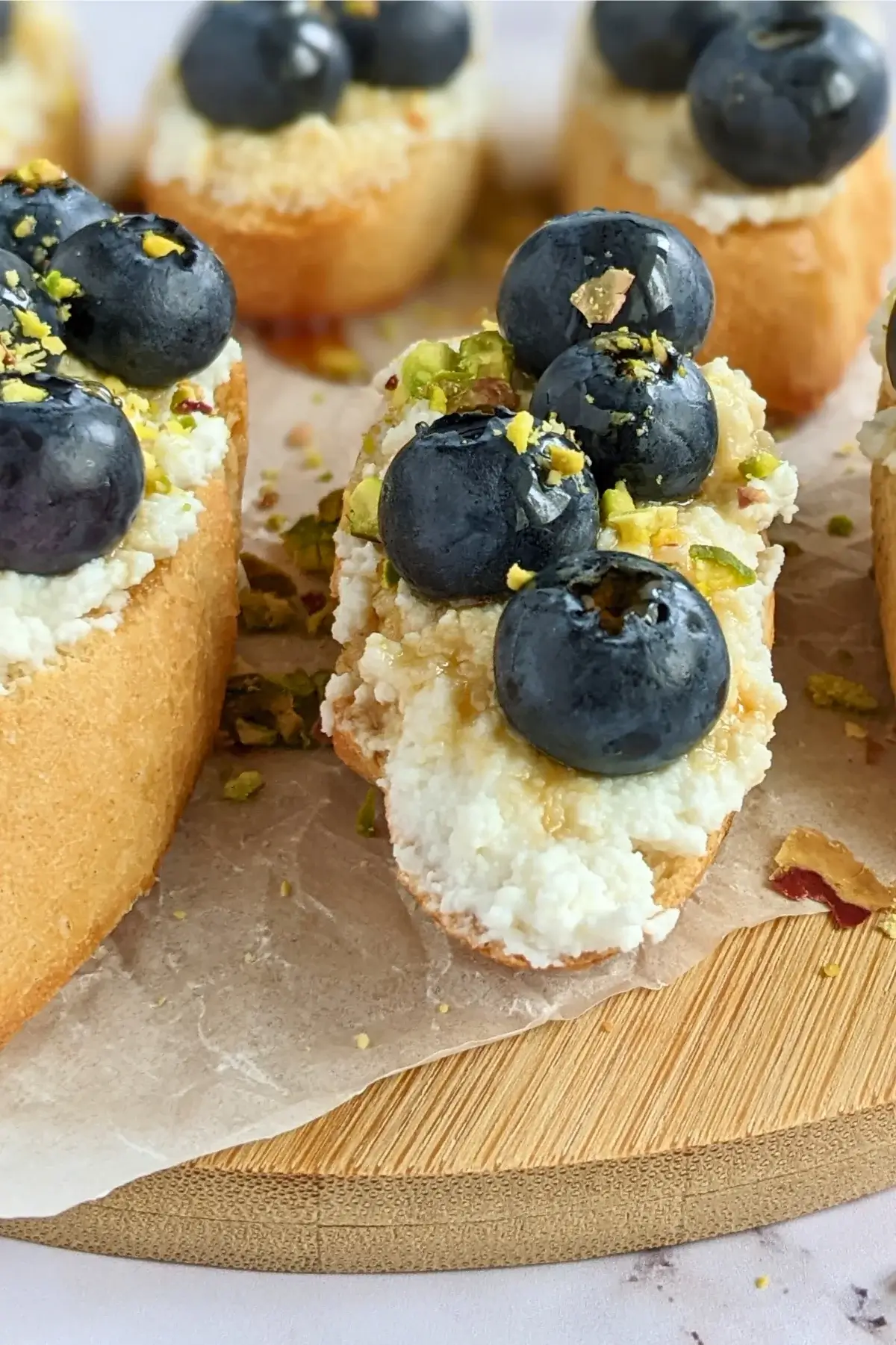 Crostini topped with sweet ricotta and fresh blueberries, drizzled with honey.