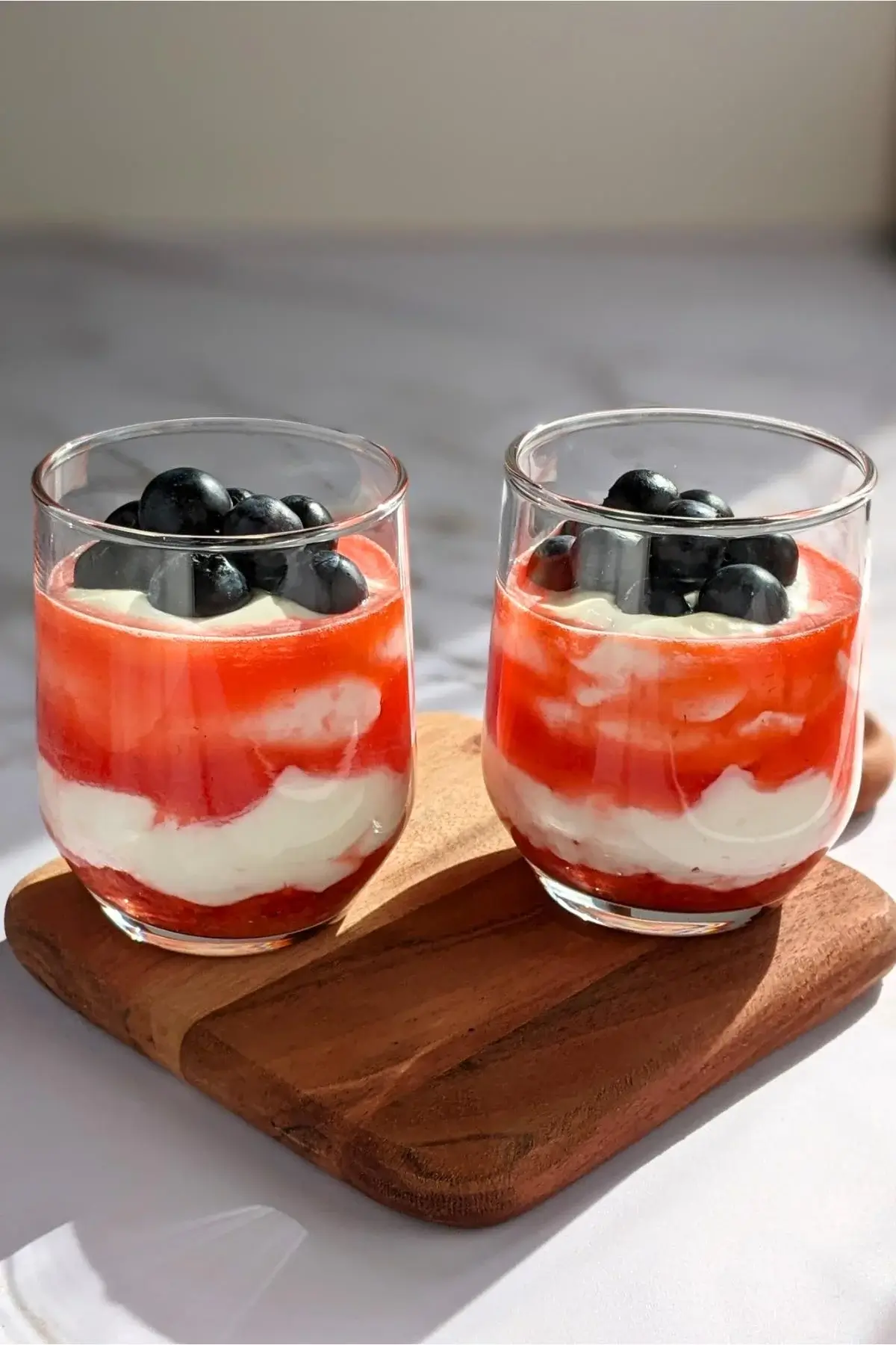 Layered berry fool dessert made with whipped cream, Greek yogurt, and a medley of fresh berries and berry syrup.