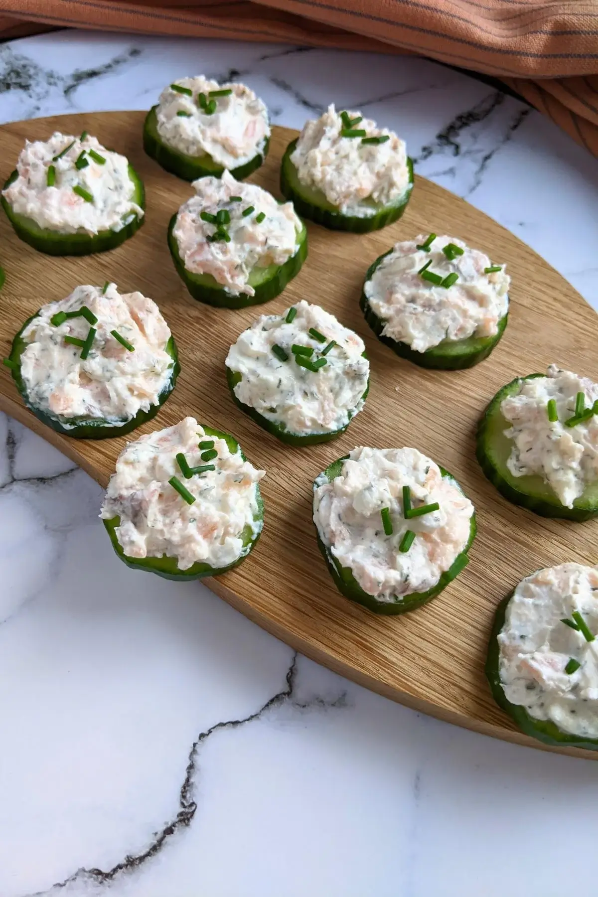 Cucumber rounds topped with smoked salmon, cream cheese, and herb mix for a light and elegant bite.