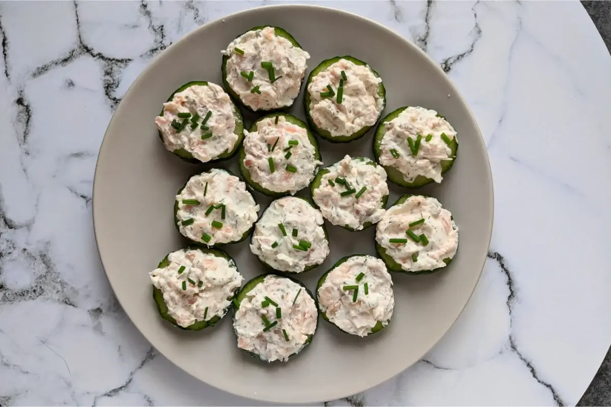 Cucumber rounds topped with smoked salmon, cream cheese, and herb mix for a light and elegant bite.