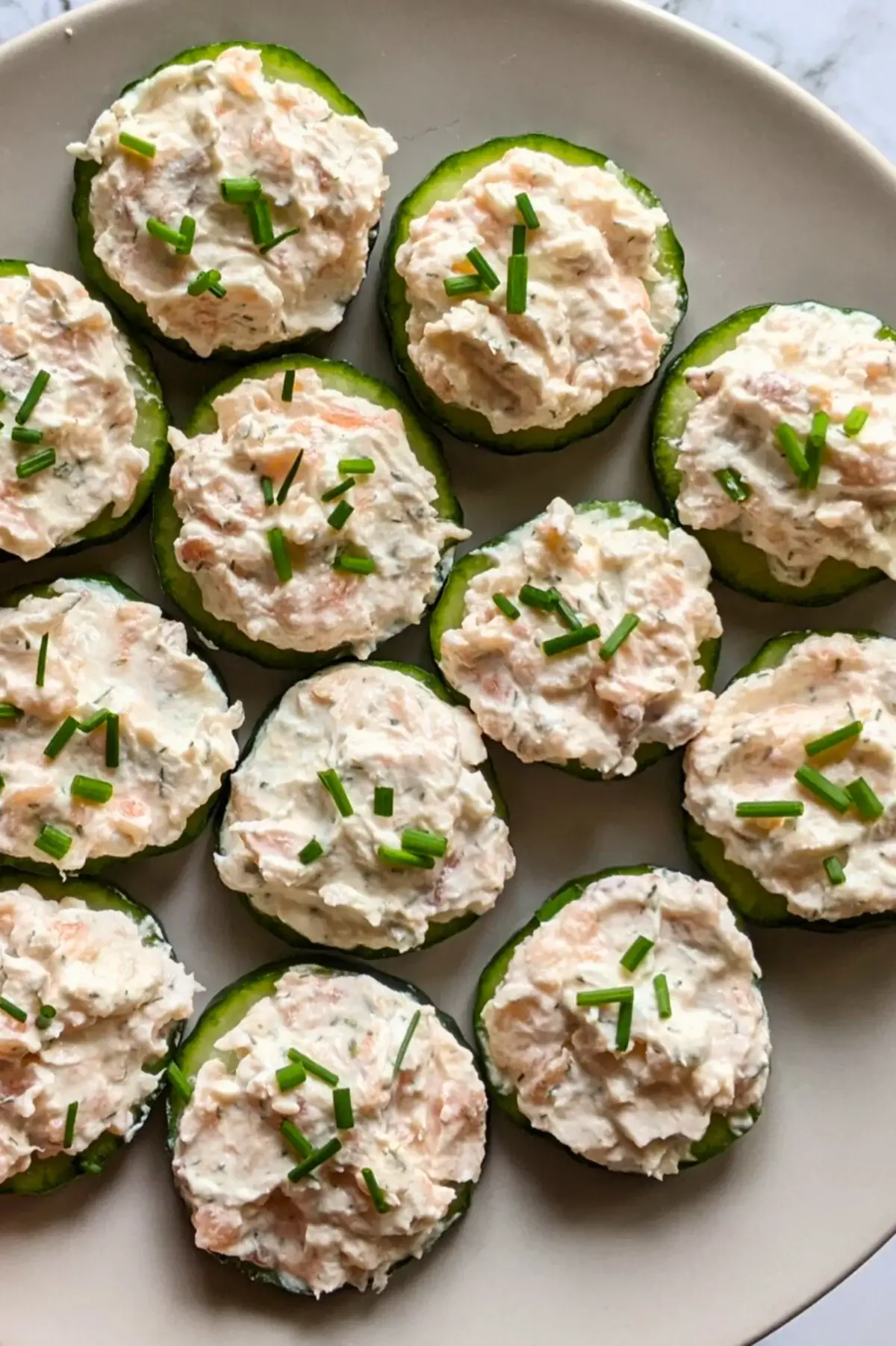 Smoked salmon cucumber bites with lemon-chive cream cheese spread.