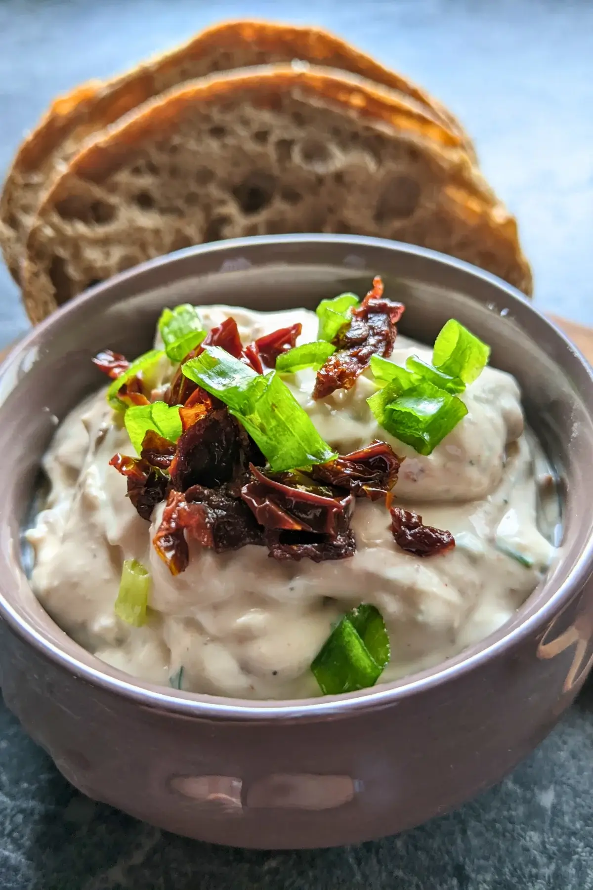 Creamy feta and sundried tomato dip served with bread slices and puff pastry sticks.