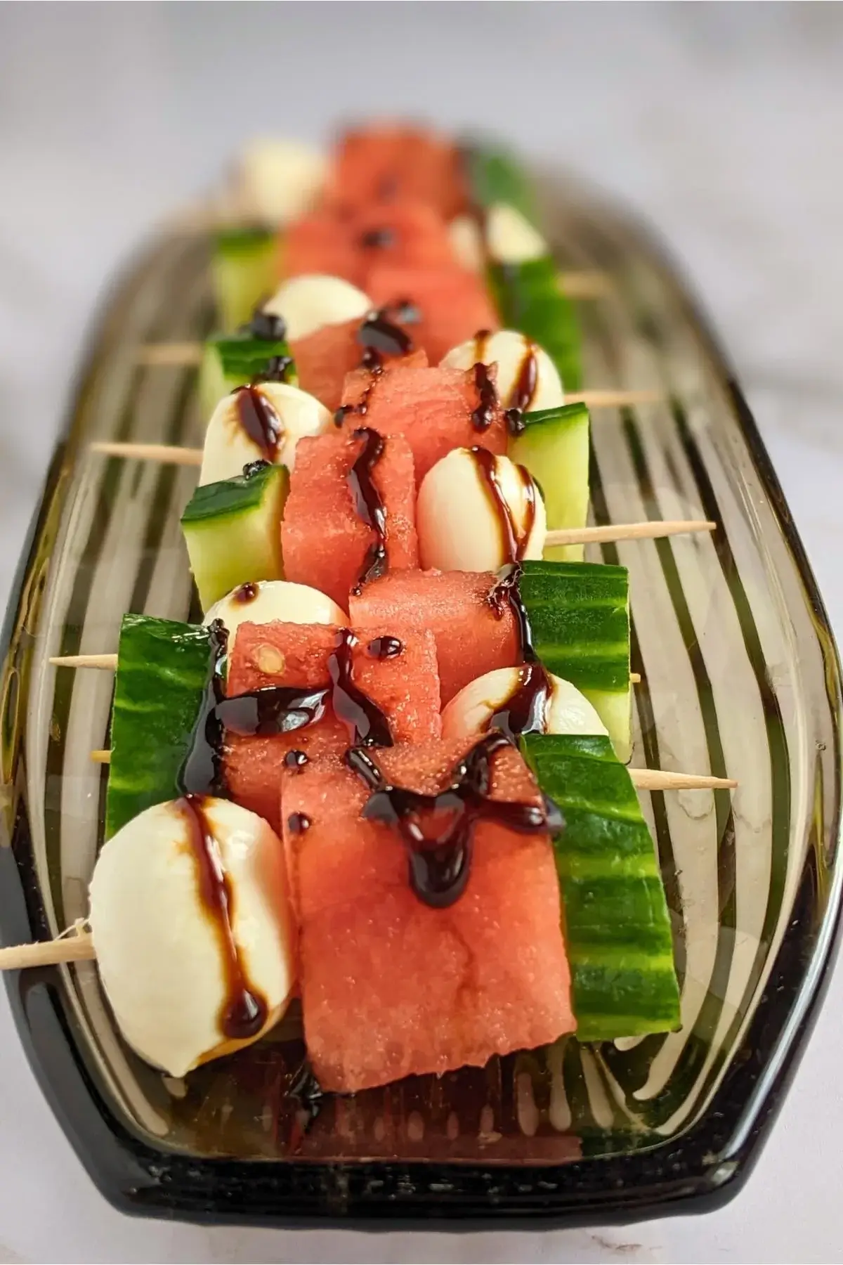 Colorful skewers with watermelon, cucumber, and mozzarella balls, perfect for cooling summer bites.