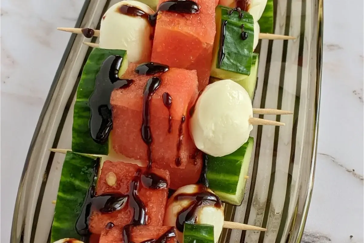 Colorful skewers with watermelon, cucumber, and mozzarella balls, perfect for cooling summer bites.