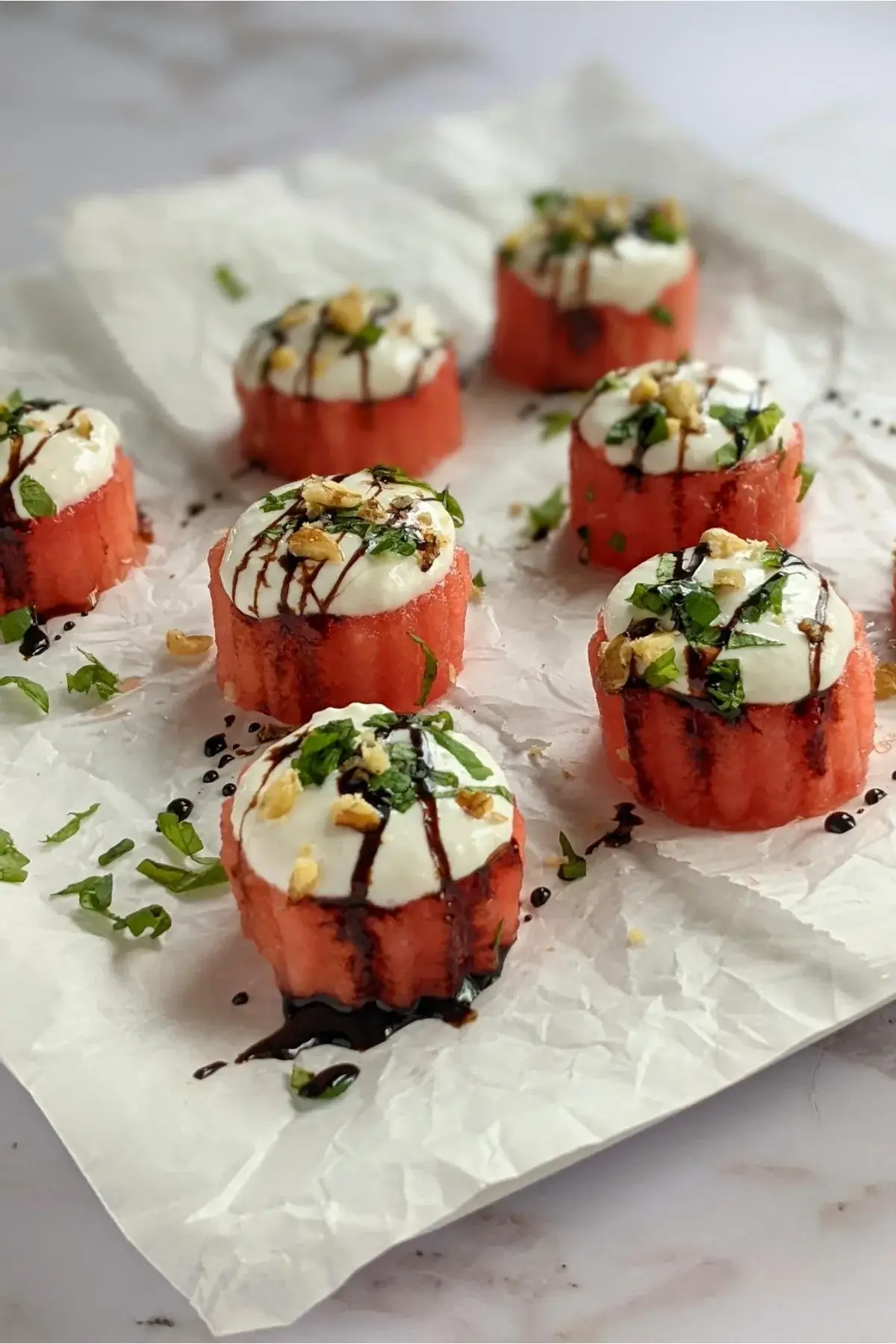 Juicy watermelon rounds topped with creamy goat cheese and fresh herbs for a flavorful contrast.