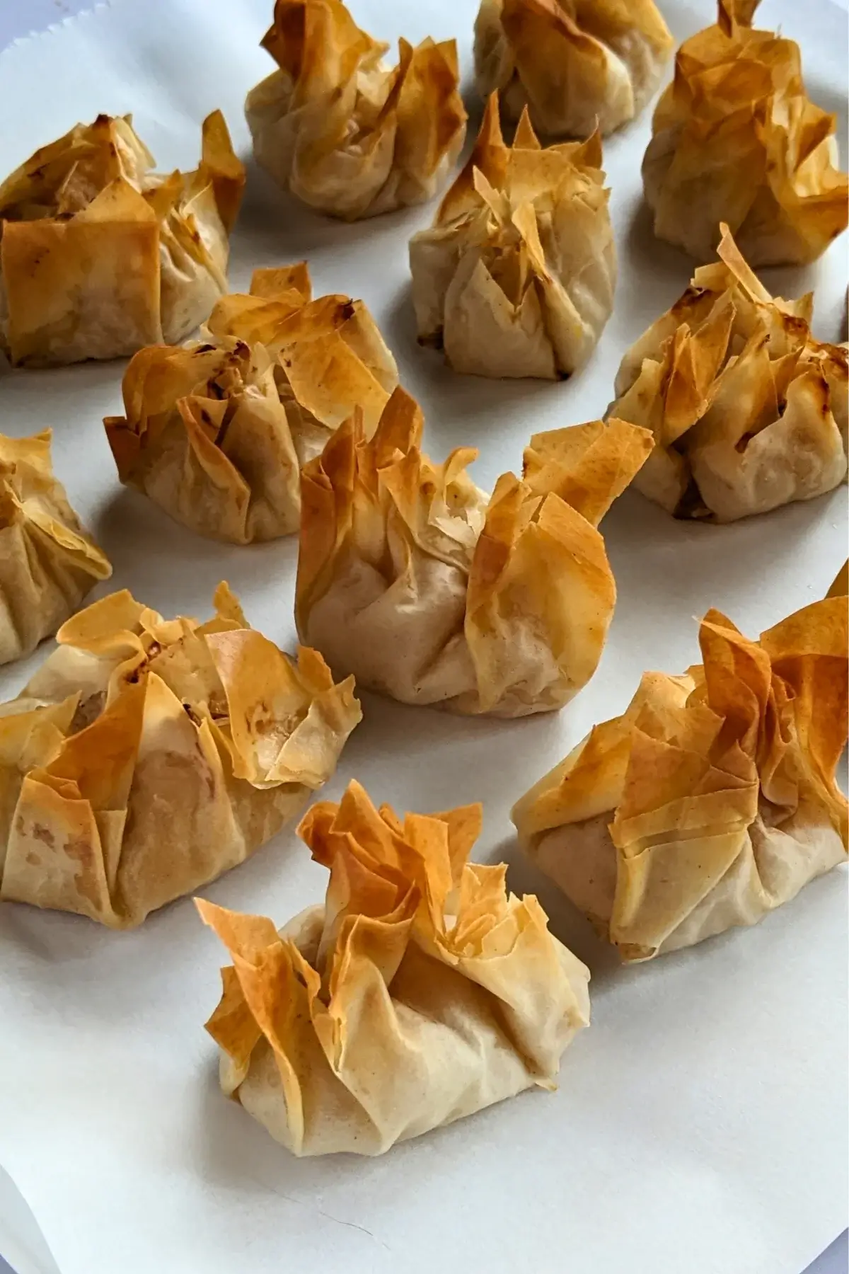 Golden phyllo pastry parcels filled with ricotta and applesauce, lightly crisped.