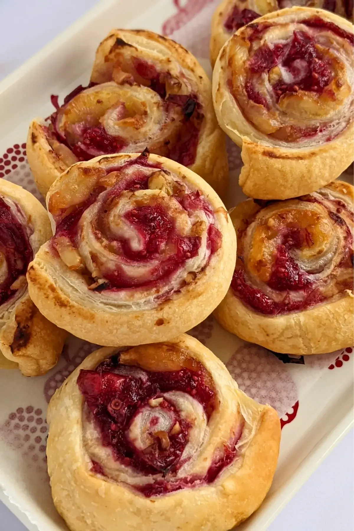 Flaky cranberry brie pinwheel bites with puff pastry filled with melted brie and tart cranberry sauce.