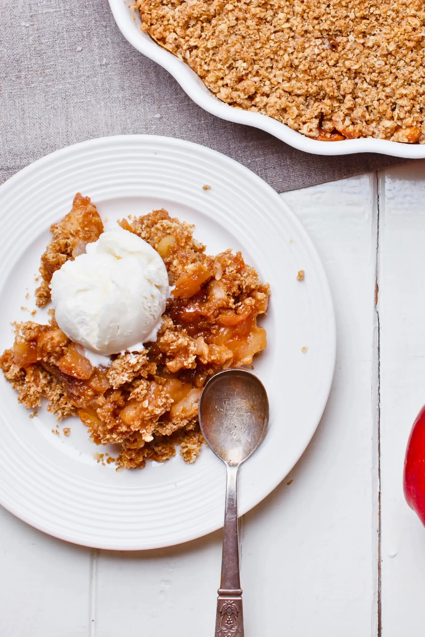 Fruit-filled crumble with a golden, crumbly topping and chunks of rhubarb and apple at the bottom.