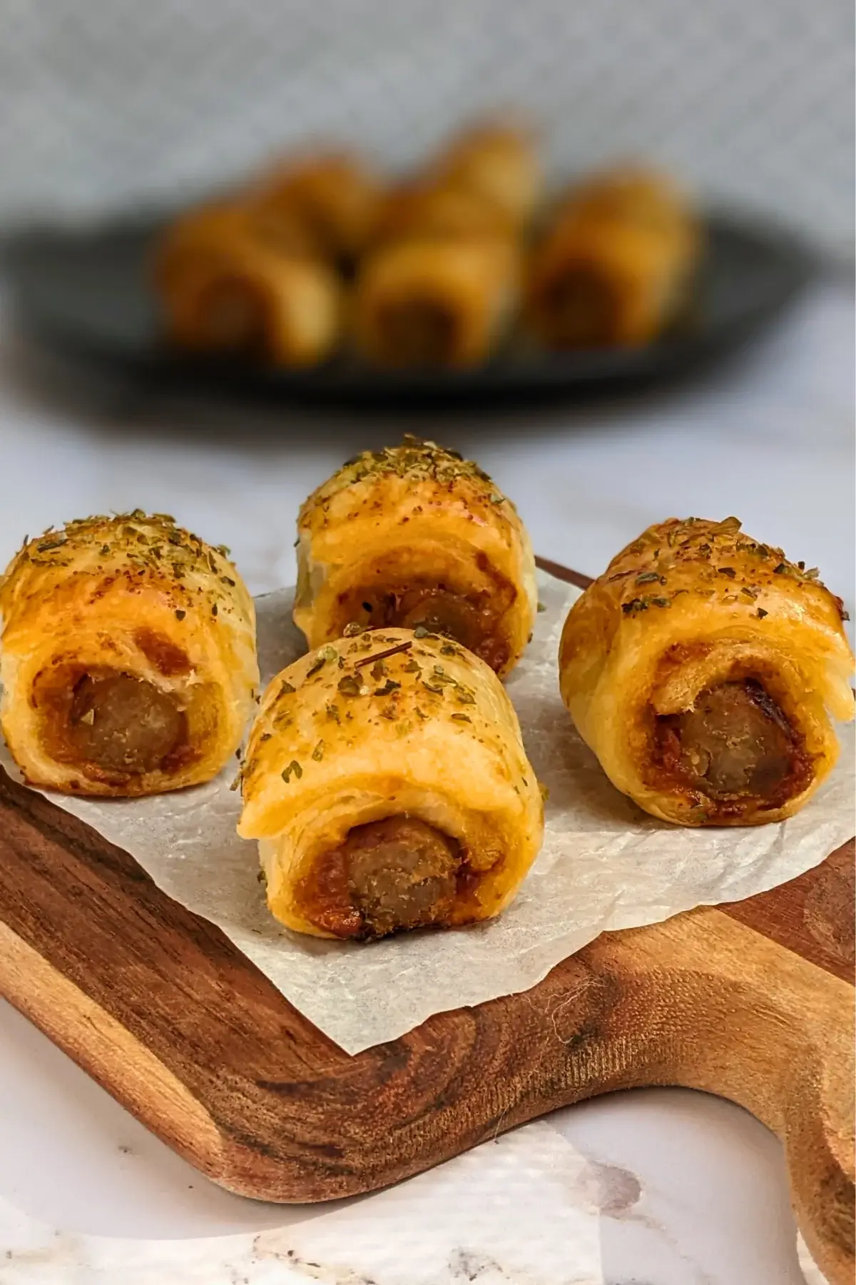 Mini Italian sausage rolls with puff pastry - a puff pastry appetizer filled with baked Italian-style sausages, topped with parmesan cheese and a salsa, mustard, and balsamic vinegar sauce.
