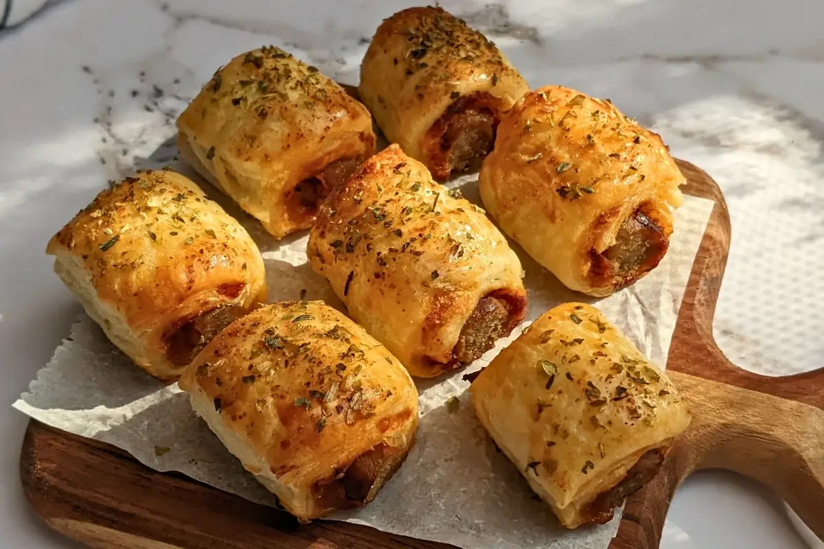 Mini Italian sausage rolls with puff pastry - a puff pastry appetizer filled with baked Italian-style sausages, topped with parmesan cheese and a salsa, mustard, and balsamic vinegar sauce.