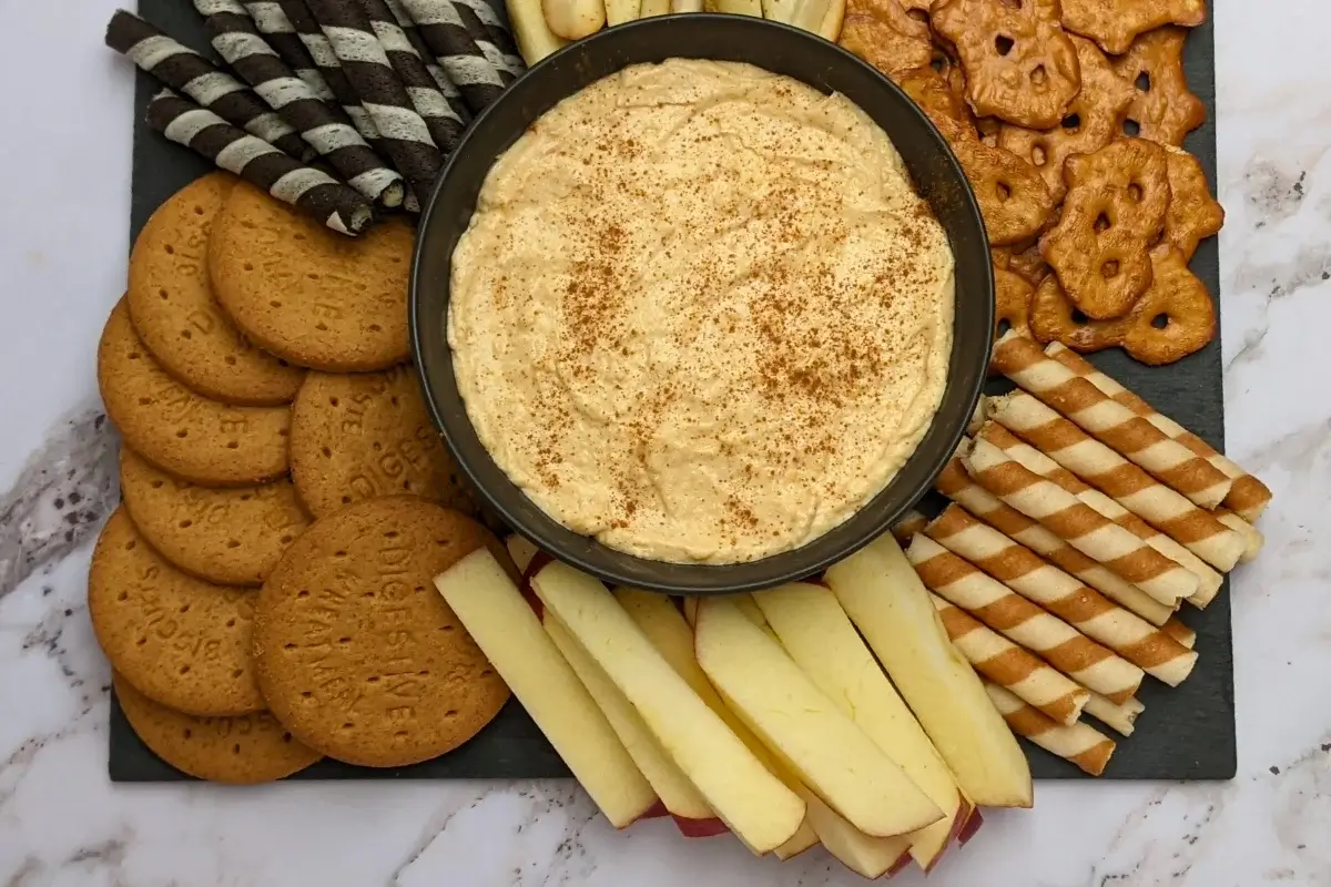 Pumpkin dip with cream cheese, cinnamon, pumpkin pie spice and Greek yogurt served with sliced apples and pears, vanilla wafer sticks, biscuits, and pretzels.