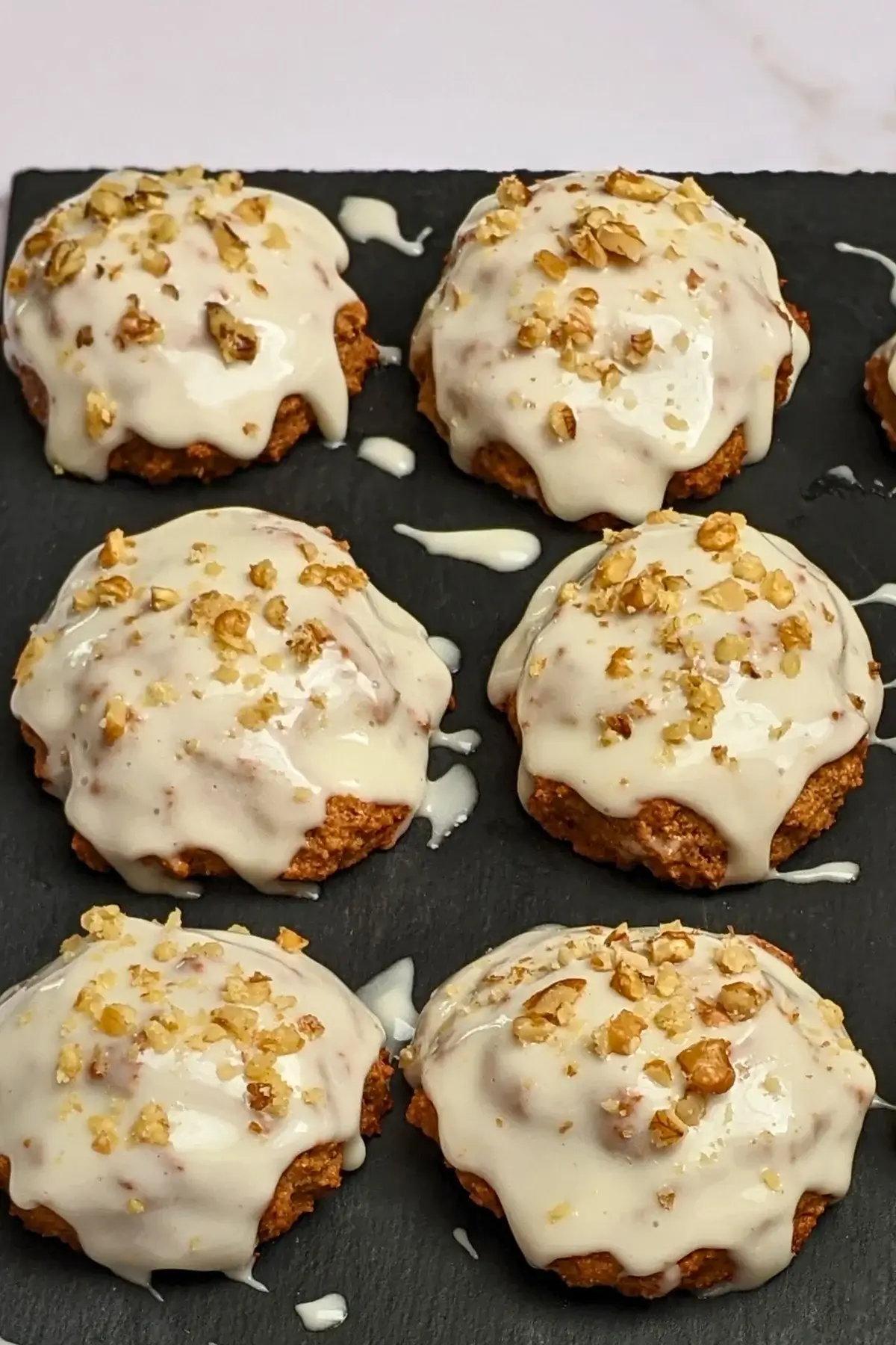 Applesauce cookies with cream cheese frosting - healthier fall cookies made with applesauce, wholemeal flour, and a mix of white and coconut sugar, topped with a cream cheese frosting and crushed walnuts.