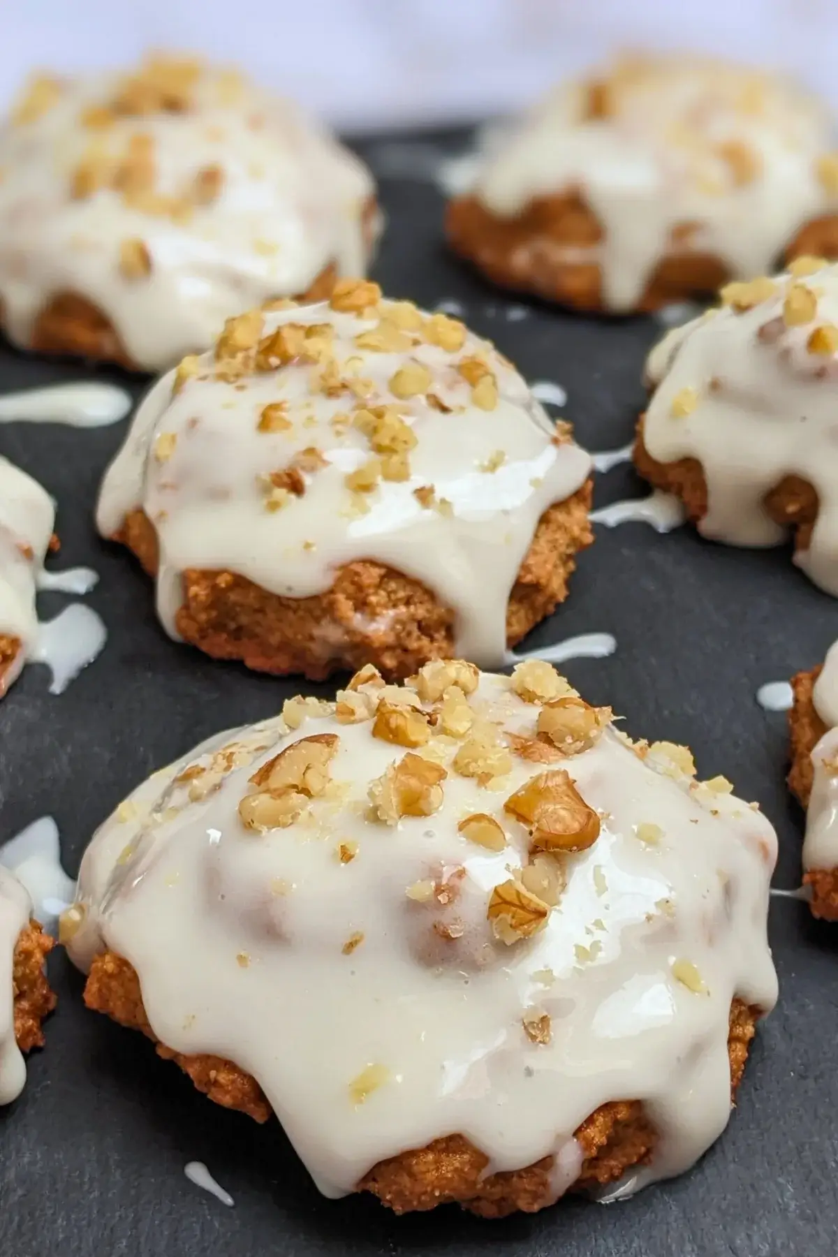 Applesauce cookies with cream cheese frosting - healthier fall cookies made with applesauce, wholemeal flour, and a mix of white and coconut sugar, topped with a cream cheese frosting and crushed walnuts.