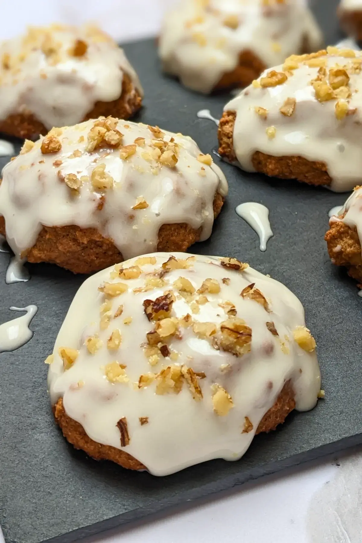 Applesauce cookies with cream cheese frosting - healthier fall cookies made with applesauce, wholemeal flour, and a mix of white and coconut sugar, topped with a cream cheese frosting and crushed walnuts.