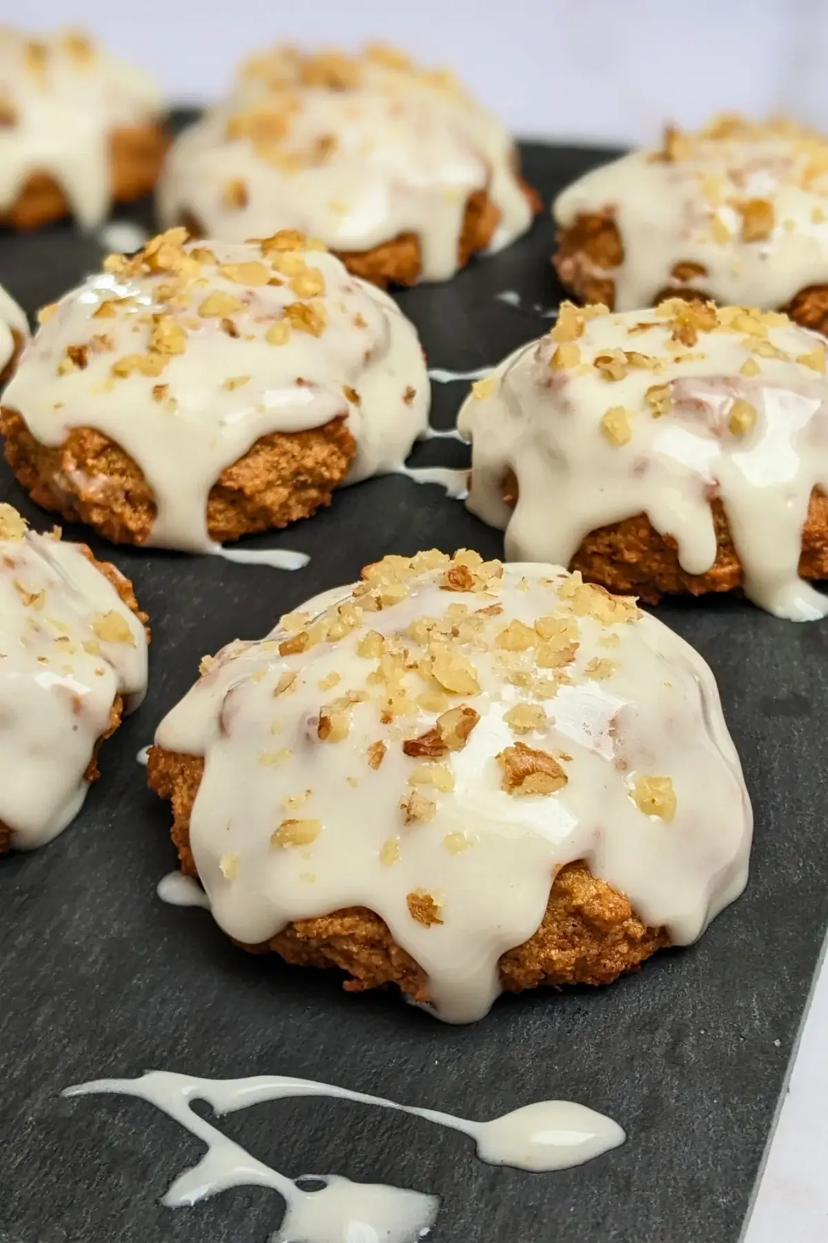 Applesauce cookies with cream cheese frosting - healthier fall cookies made with applesauce, wholemeal flour, and a mix of white and coconut sugar, topped with a cream cheese frosting and crushed walnuts.