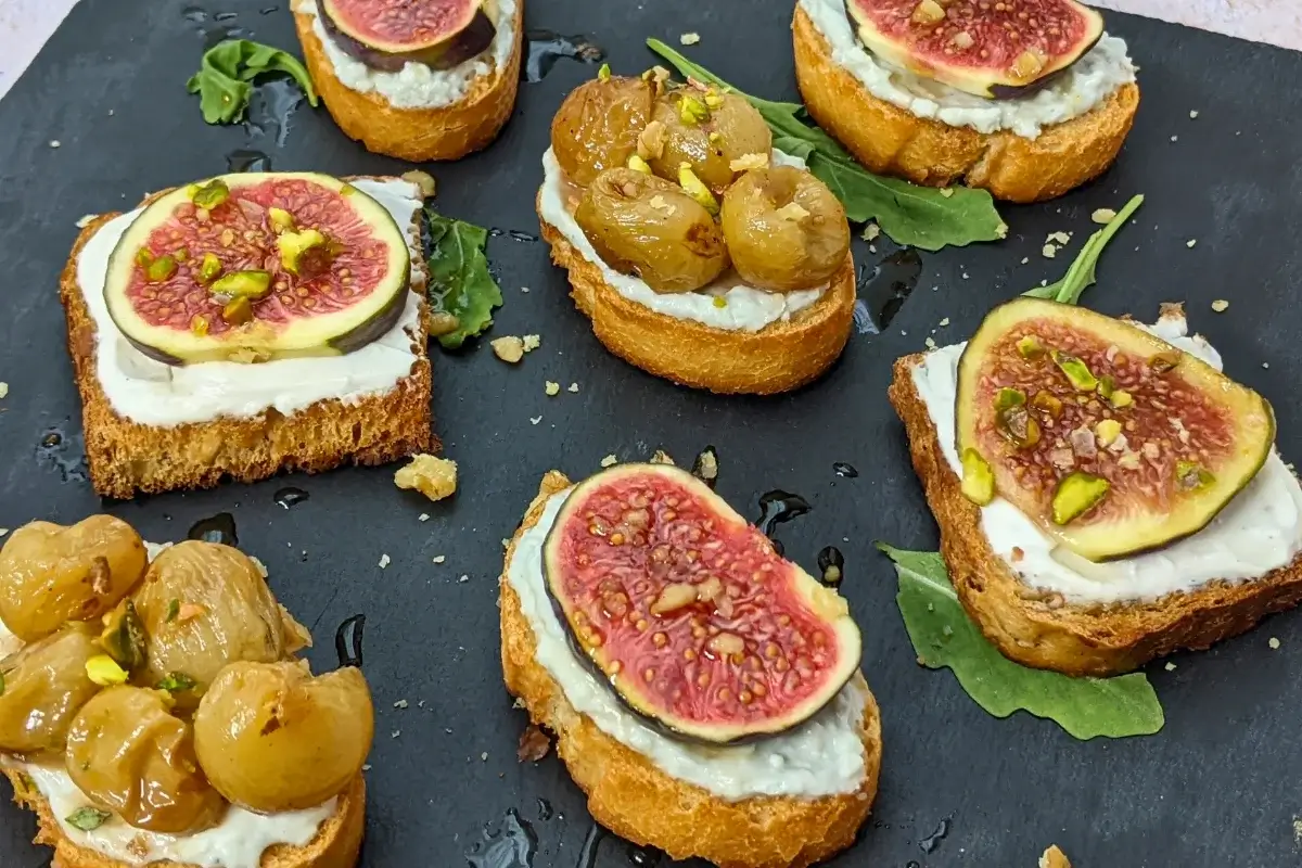 Cheese and Fruits Crostini Appetizers Platter - Italian crostini party food platter with cheese and fruit toppings.