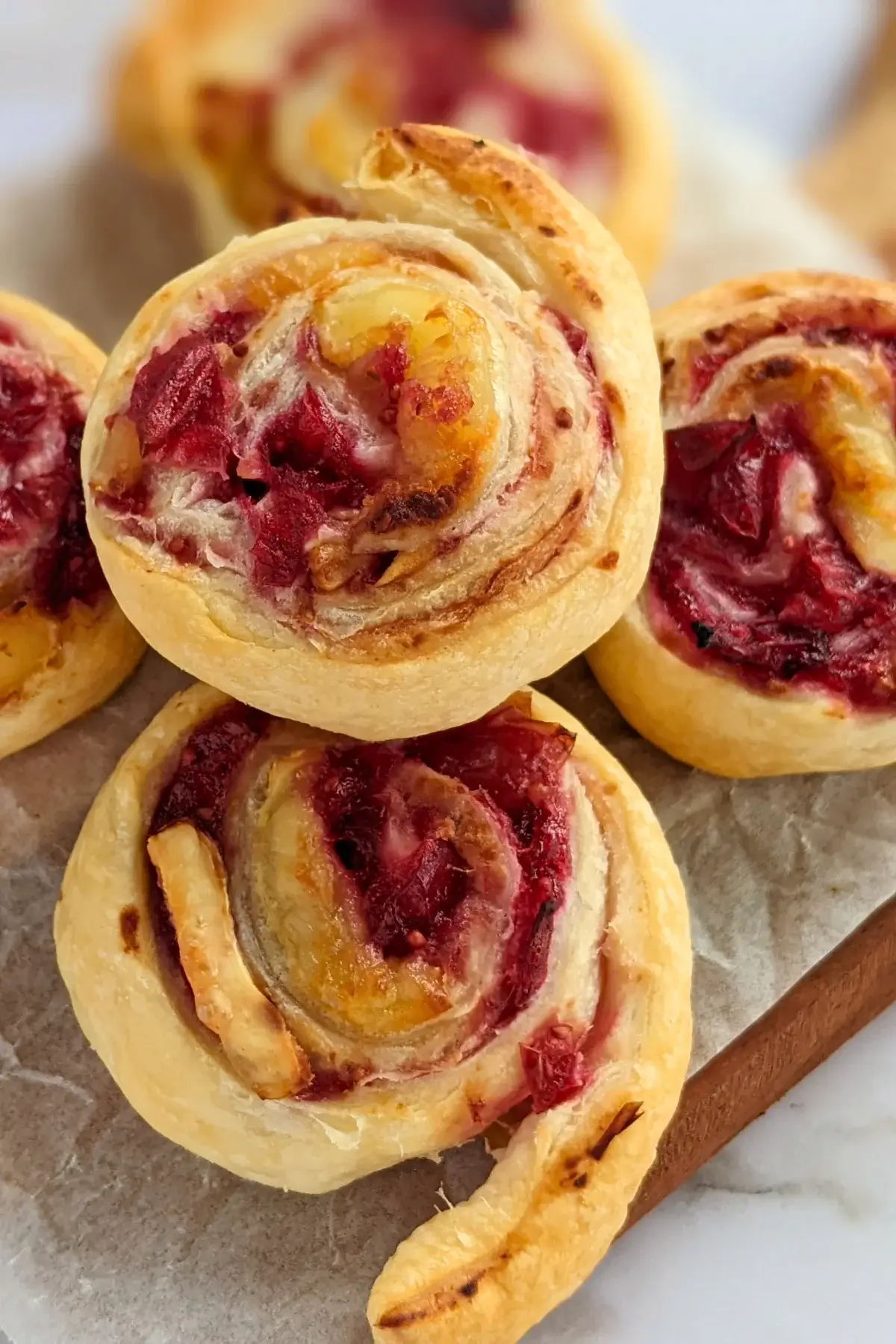 Flaky cranberry brie pinwheel bites with puff pastry filled with melted brie and tart homemade cranberry sauce plus walnuts.