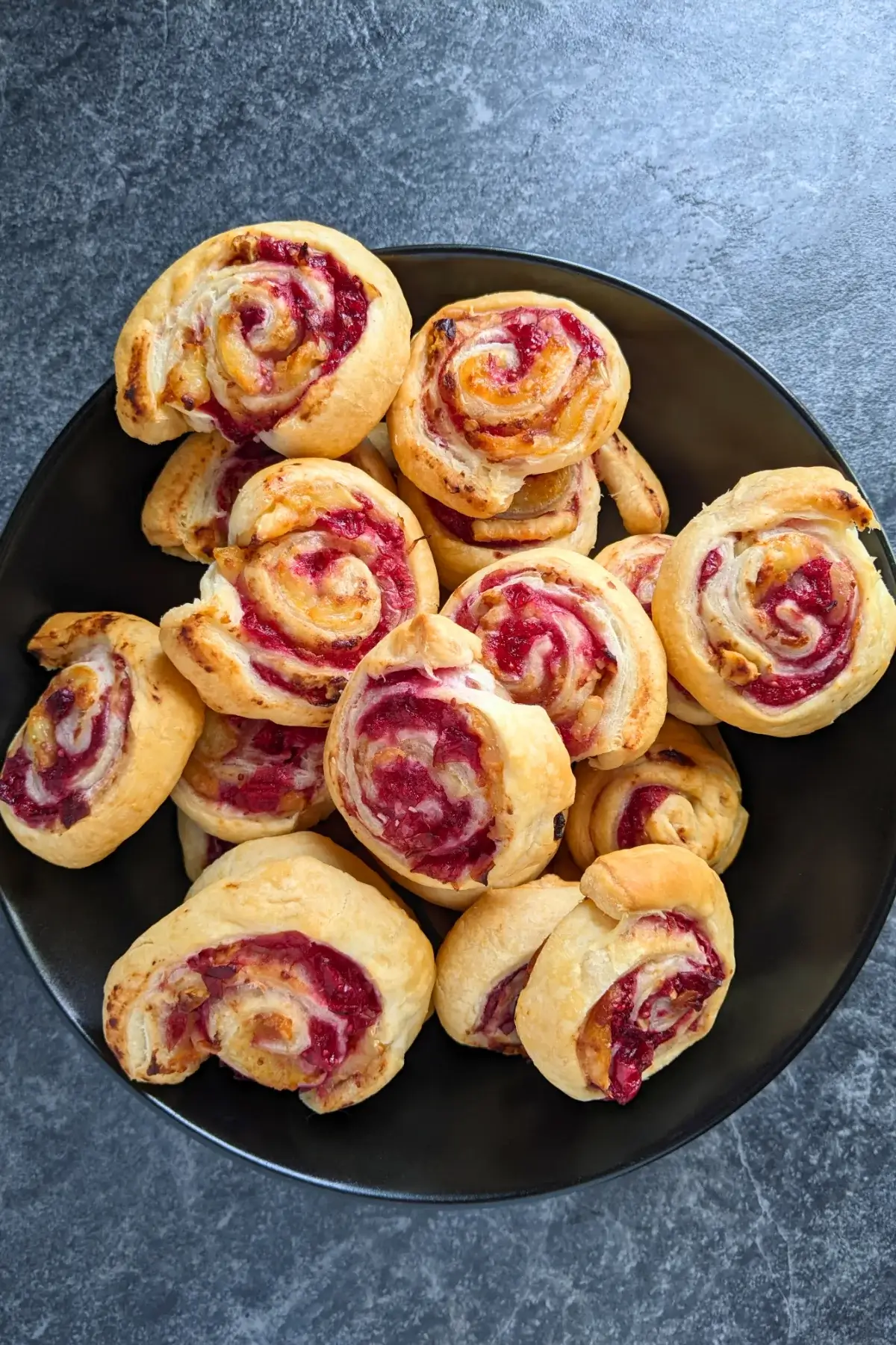 Flaky cranberry brie pinwheel bites with puff pastry filled with melted brie and tart homemade cranberry sauce plus walnuts.
