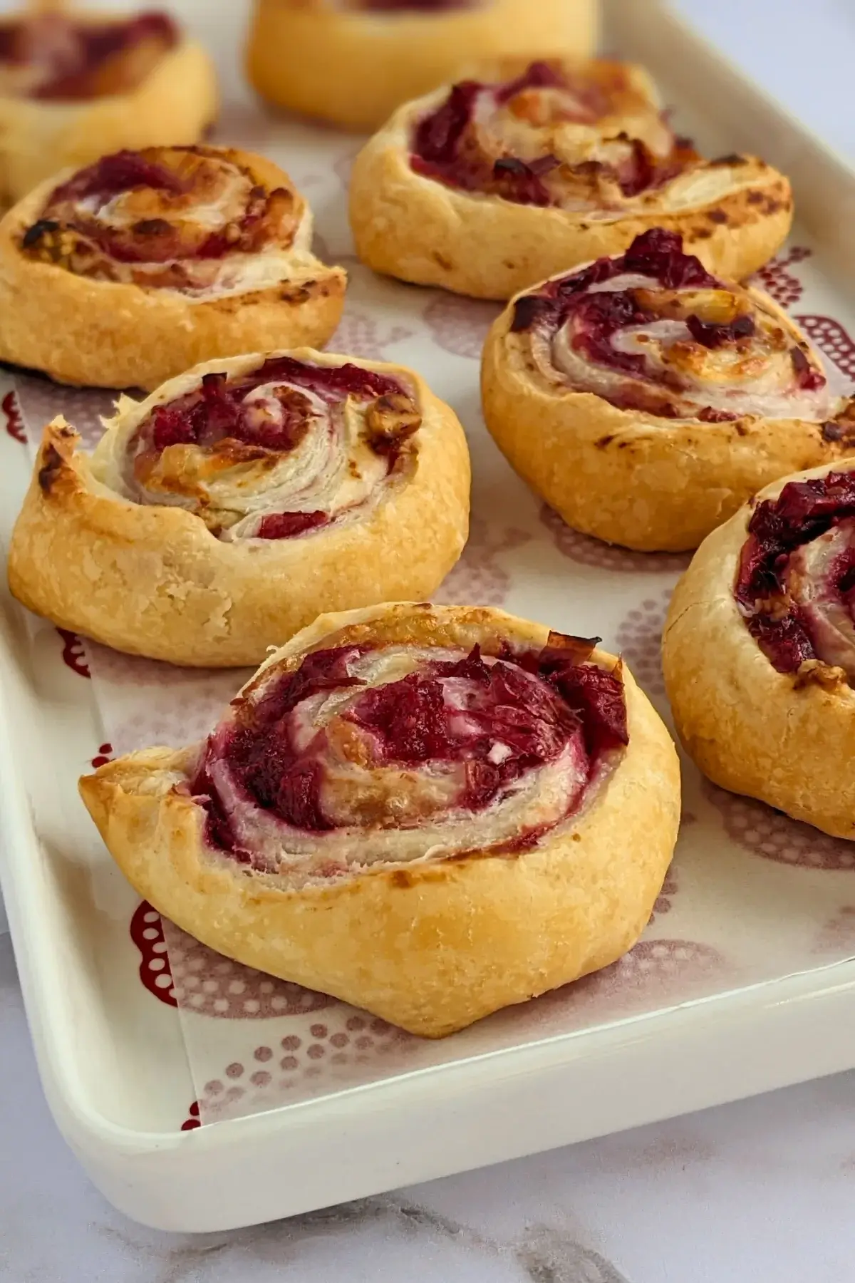 Flaky cranberry brie pinwheel bites with puff pastry filled with melted brie and tart homemade cranberry sauce plus walnuts.