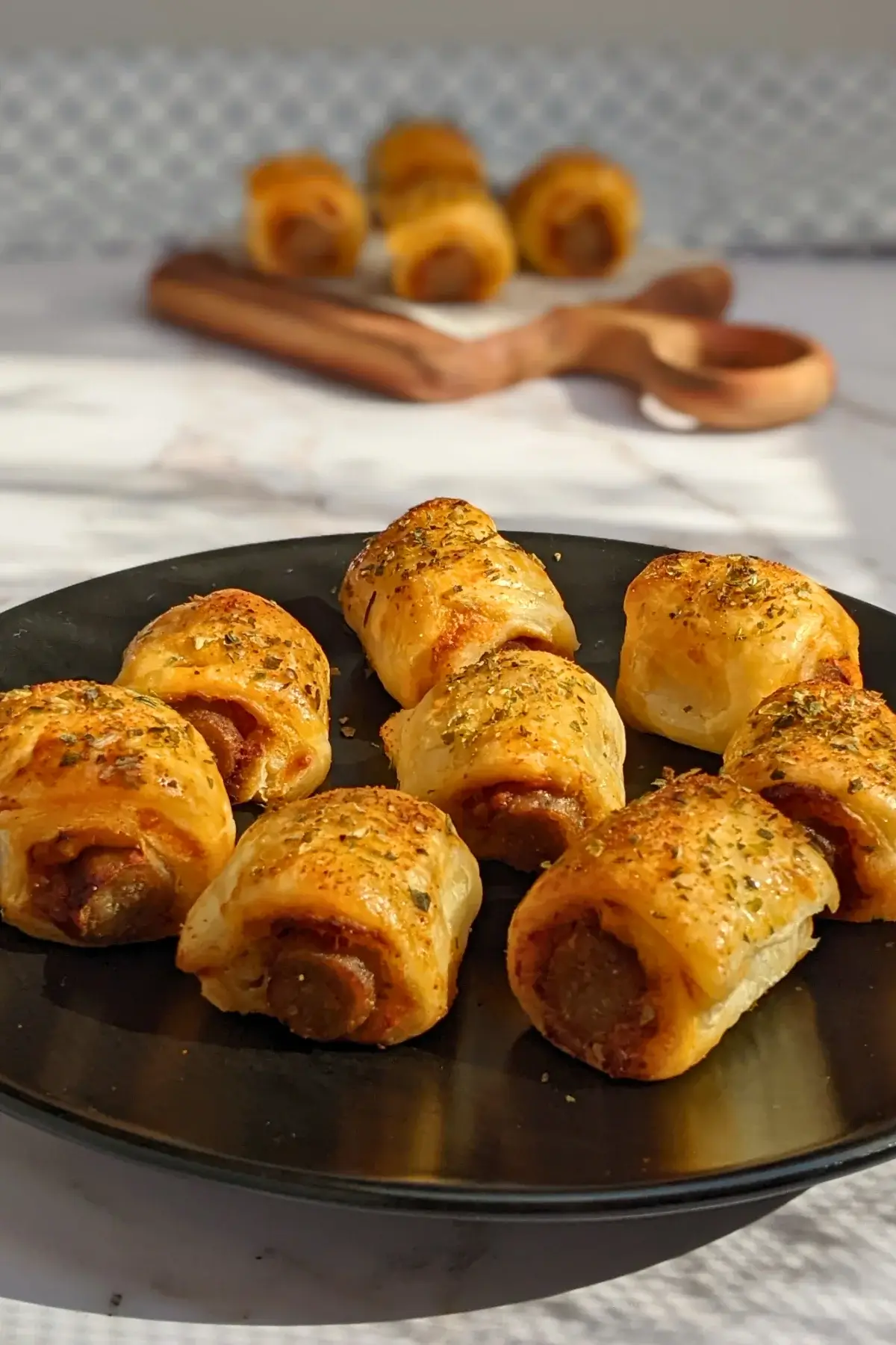 Mini Italian sausage rolls with puff pastry - a puff pastry appetizer filled with baked Italian-style sausages, topped with parmesan cheese and a salsa, mustard, and balsamic vinegar sauce.