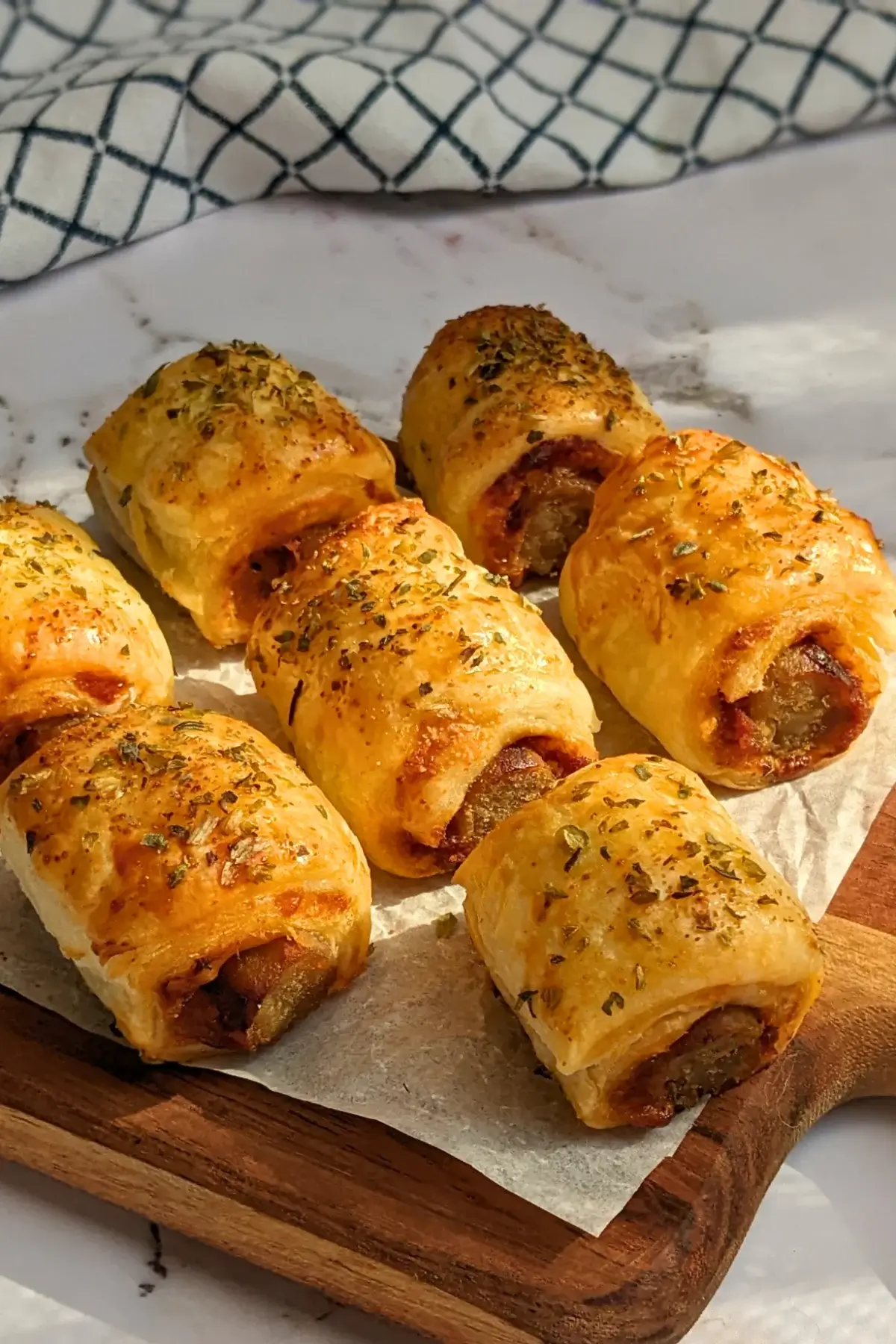 Mini Italian sausage rolls with puff pastry - a puff pastry appetizer filled with baked Italian-style sausages, topped with parmesan cheese and a salsa, mustard, and balsamic vinegar sauce.
