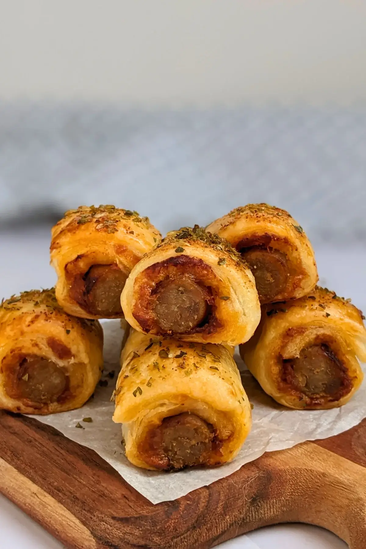 Mini Italian sausage rolls with puff pastry - a puff pastry appetizer filled with baked Italian-style sausages, topped with parmesan cheese and a salsa, mustard, and balsamic vinegar sauce.