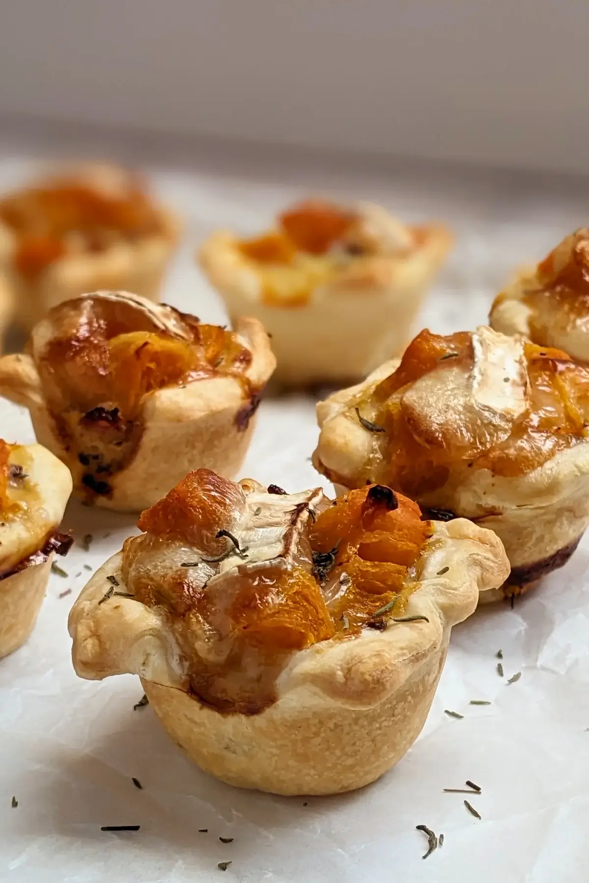 Mini Pumpkin Quiche Cups With Puff Pastry - mini quiche appetizers made in a mini muffin tin with cooked pumpkin, caramelized onions, and crispy ham in puff pastry cups.