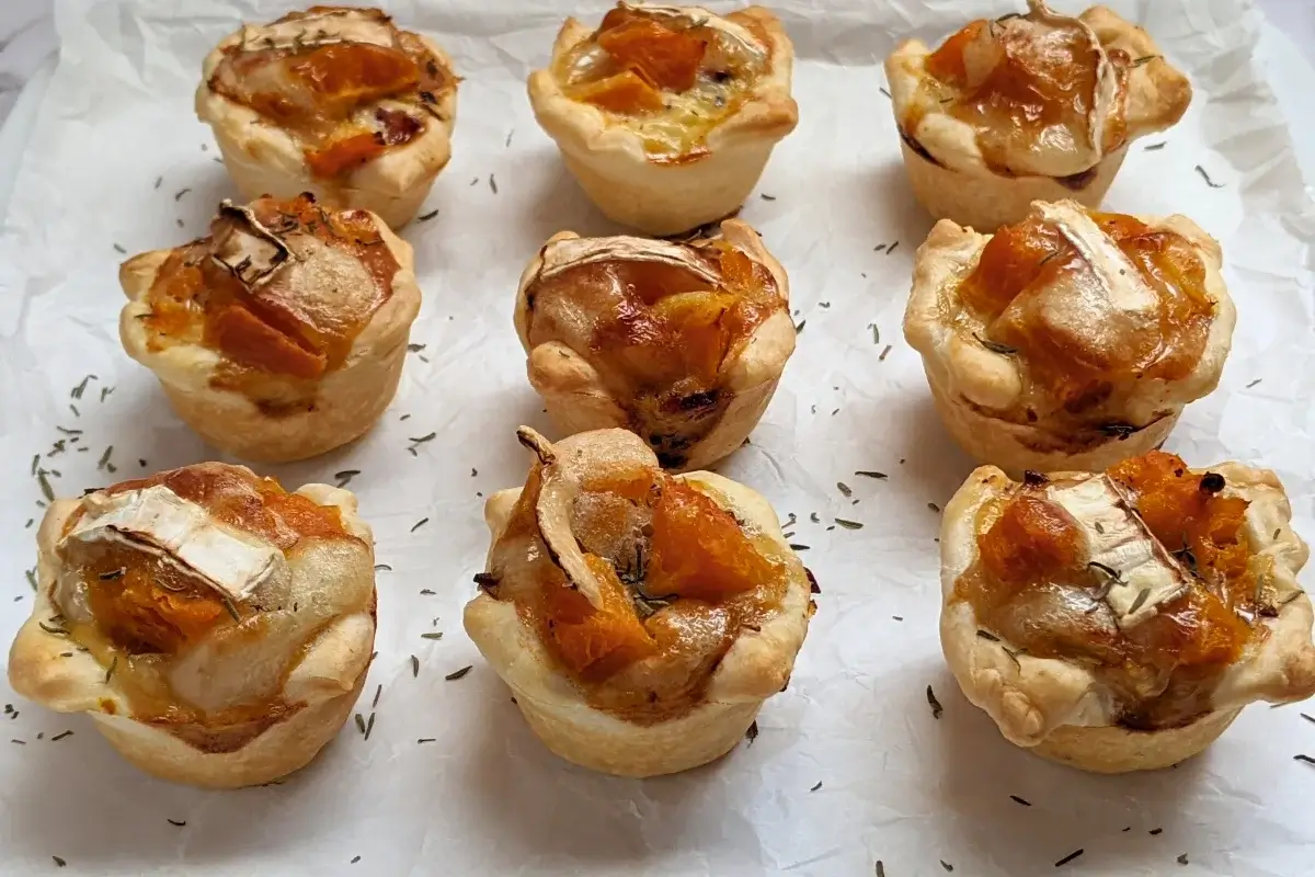 Mini Pumpkin Quiche Cups With Puff Pastry - mini quiche appetizers made in a mini muffin tin with cooked pumpkin, caramelized onions, and crispy ham in puff pastry cups.