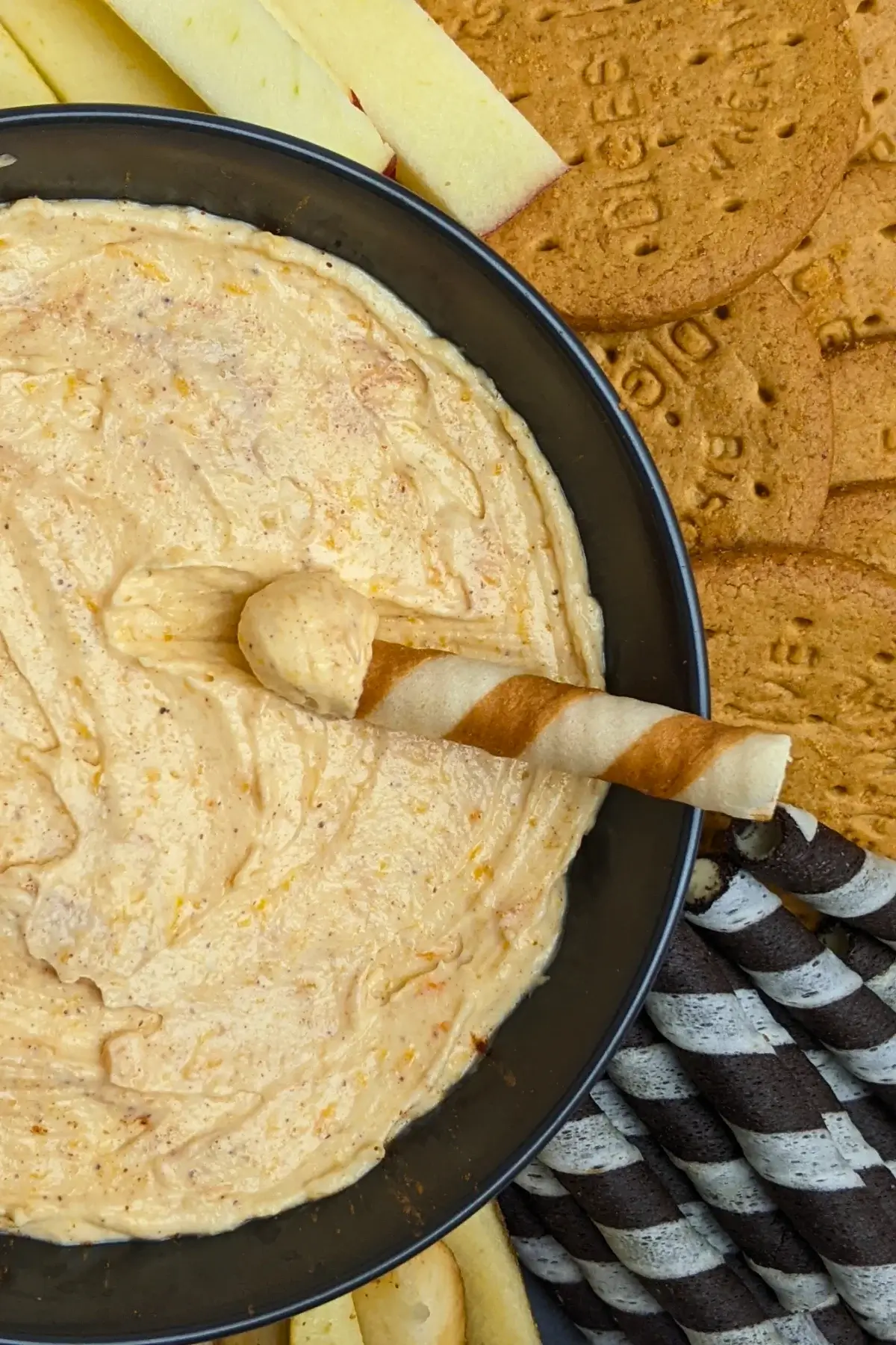 Pumpkin dip with cream cheese, cinnamon, pumpkin pie spice and Greek yogurt served with sliced apples and pears, vanilla wafer sticks, biscuits, and pretzels.