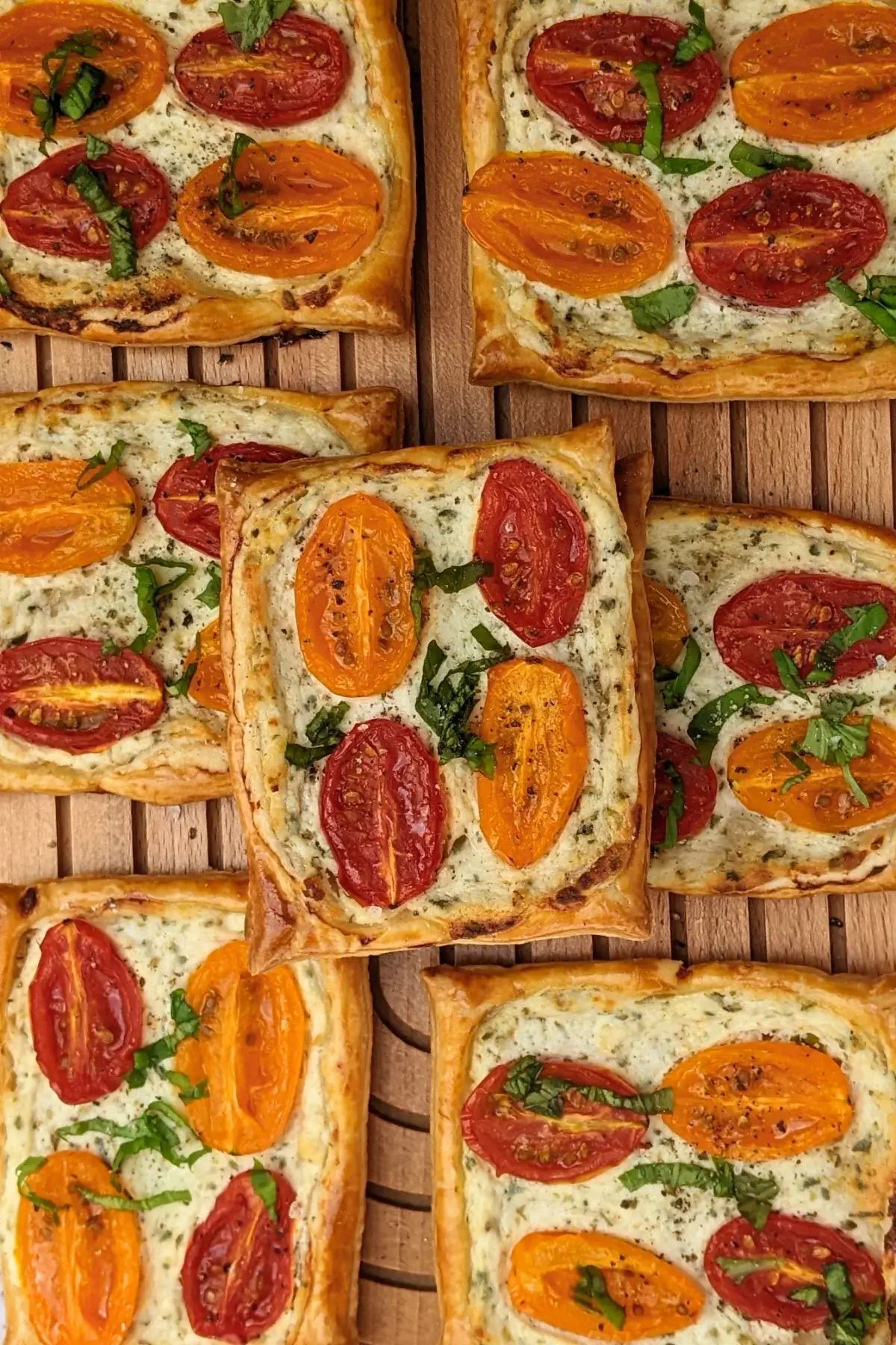 Roasted cherry tomato tarts with puff pastry - a puff pastry appetizer filled with ricotta and parmesan and topped with red and yellow cherry tomatoes and basil.