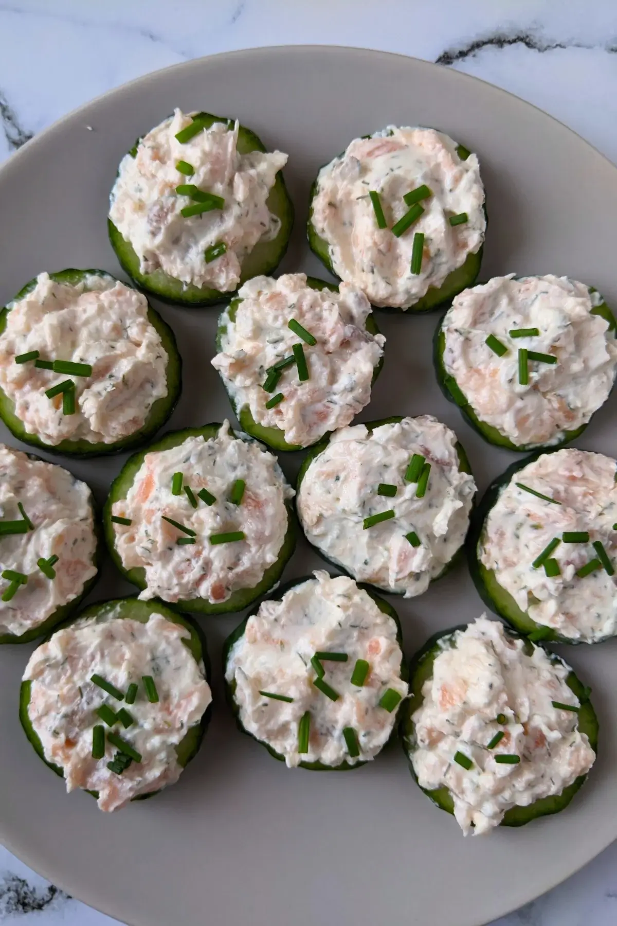 Smoked salmon cucumber bites with lemon-chive cream cheese spread.