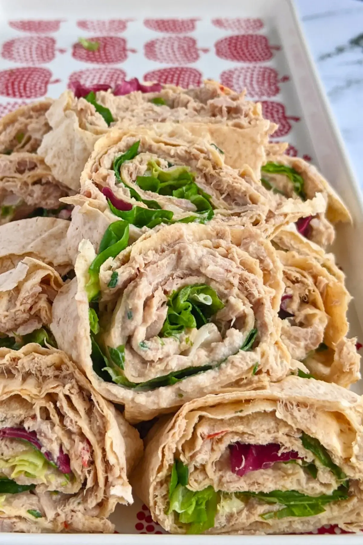 Smoked salmon flatbread rolls sliced into pinwheels filled with salmon-cream cheese spread and fresh greens.