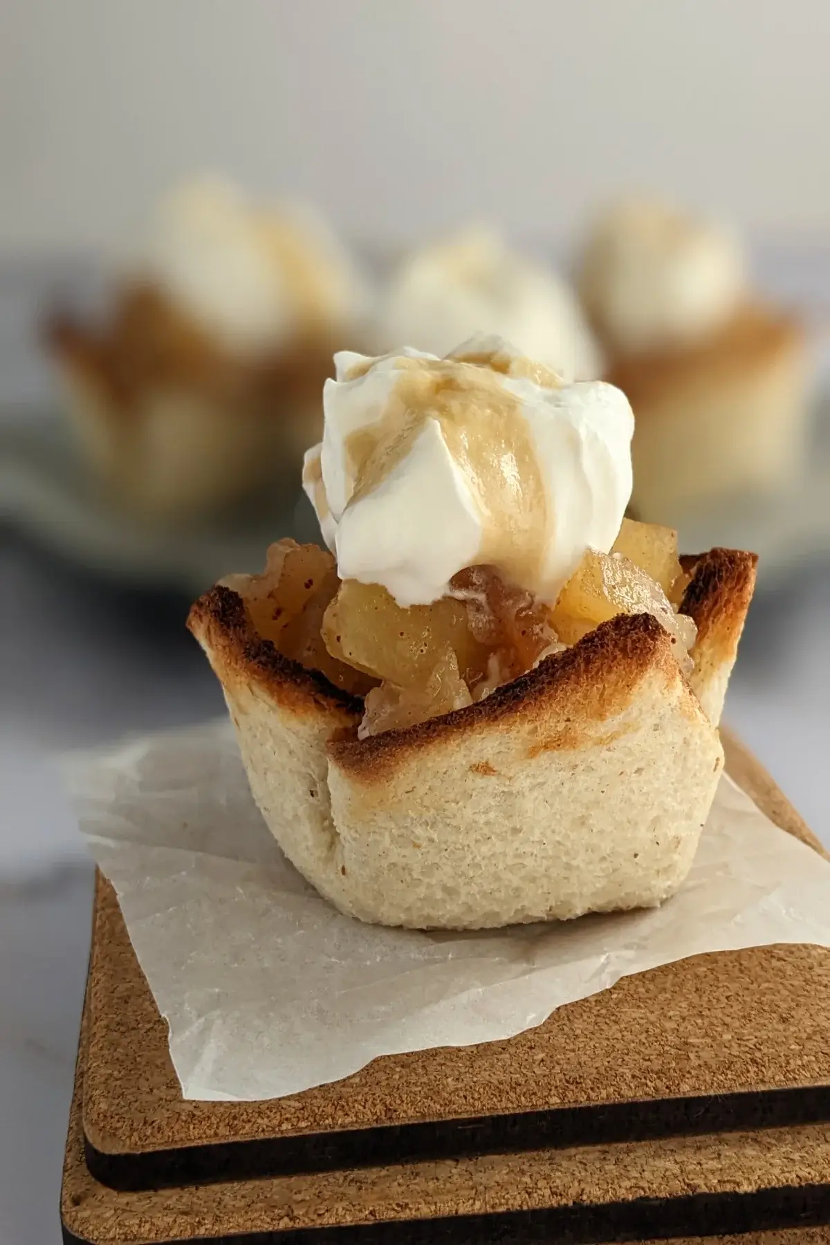 Toasted bread cups filled with homemade applesauce and topped with swirls of whipped cream.